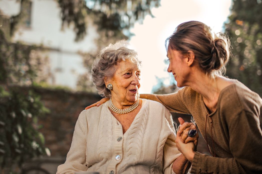 Family sharing a caring moment with elderly loved one at home